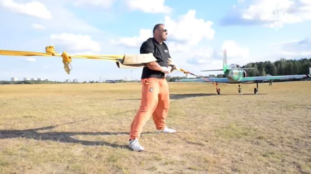 Levantador de pesas detiene con sus brazos dos avionetas