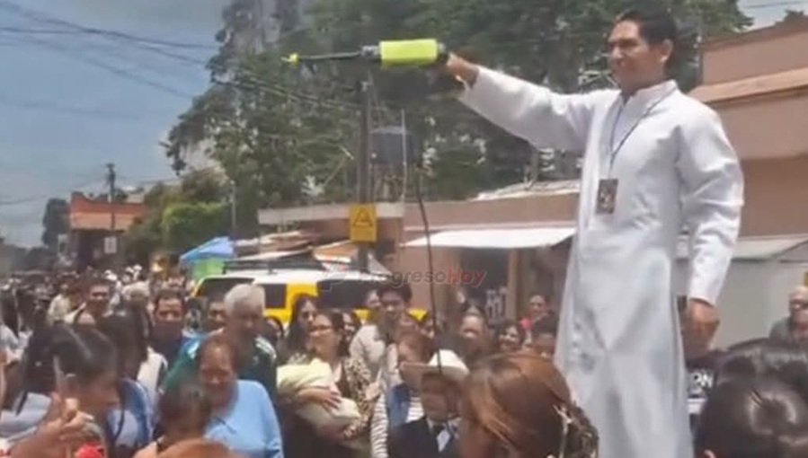 Sacerdote  vanguardista lanza a los feligreses agua bendita con una hidro lavadora